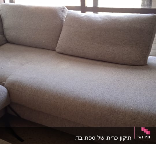 ספה אפורה עם ריפוד מרופד ליד חלון